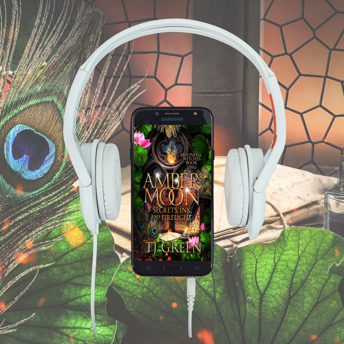 Phone displaying 'Amber Moon' book cover with headphones and peacock feather Witch fiction, paranormal mystery, urban fantasy, dual timeline fantasy