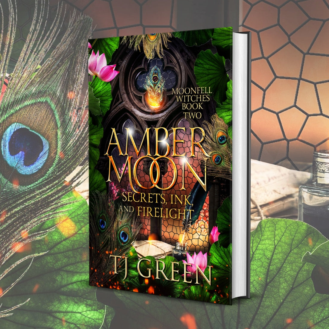 Book titled 'Amber Moon' by T.J. Green with decorative elements like peacock feathers and flowers. Paranormal Witch Fiction, mystery, urban fantasy, dual timeline historical .
