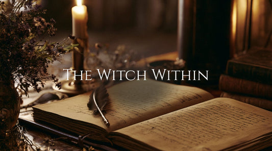 An open leather bound book with writing on the pages, a candles, and a feather quill