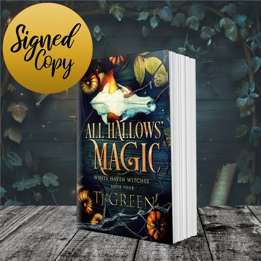 Book titled 'All Hallows' Magic' by T. Green with a signed copy label on a wooden surface and leafy background. Books about witches, fiction, Halloween, Samhain Magic.