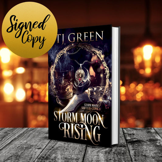 Book titled 'Storm Moon Rising' by T.J. Green with a blurred background Paranormal Wolf-shifters mysteries and urban fantasy